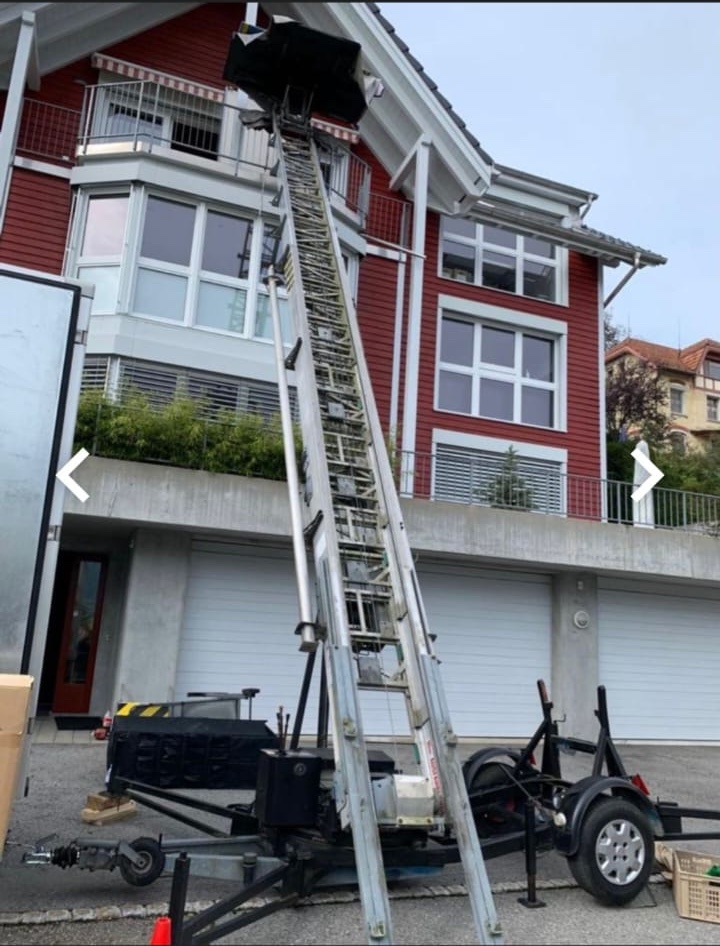 Umzugslift Umzugslift vor rotem Haus im Einsatz von dem Umzugsunternehmen Home All In One AG.